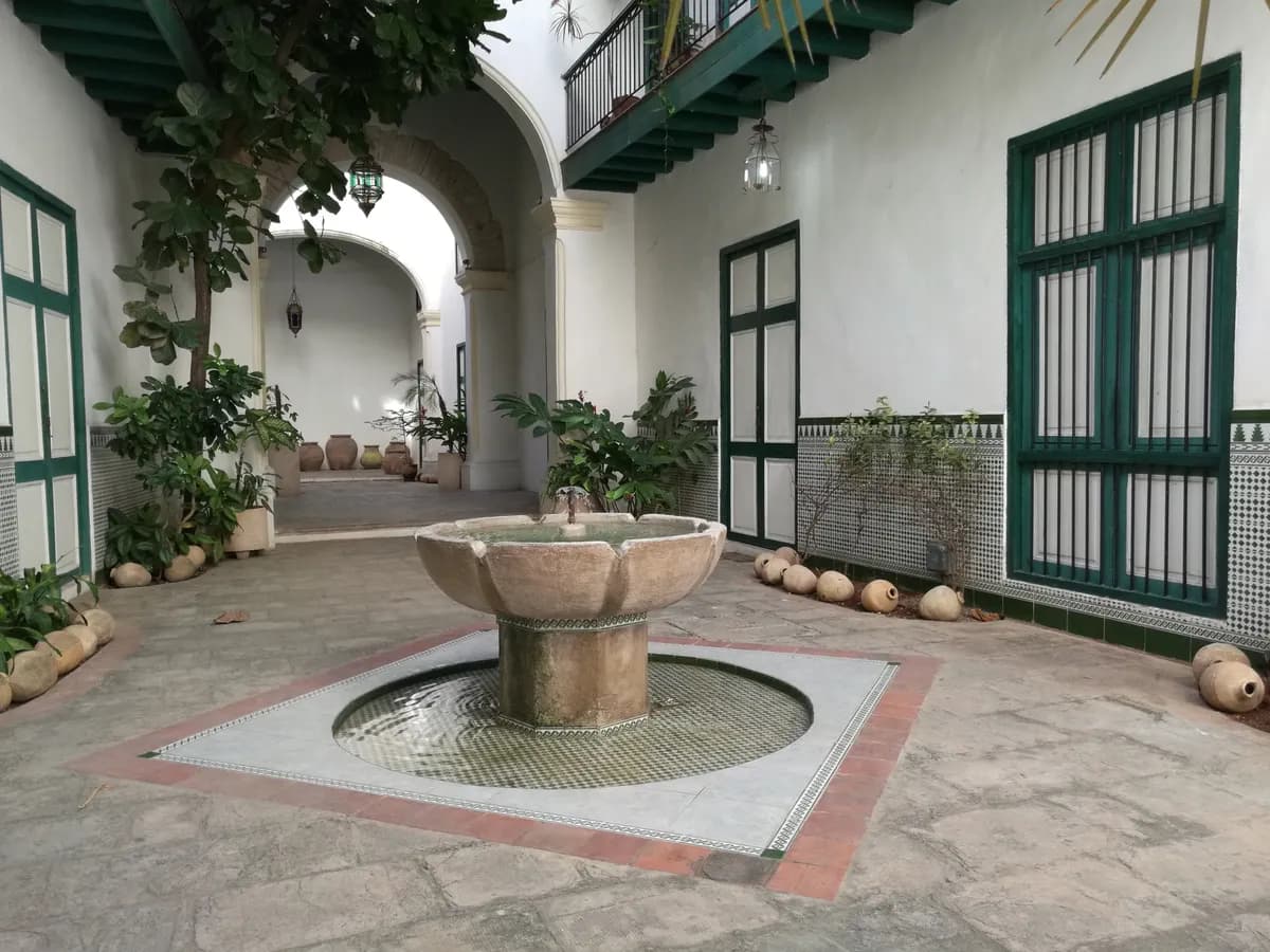 Immagine di esempio BookNoFees: cortile cubano con fontana e porte dipinte di verde