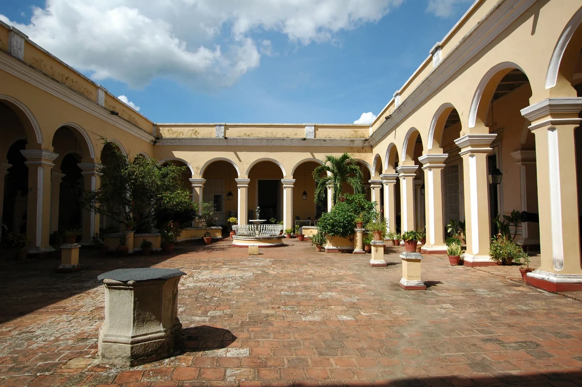Immagine di esempio BookNoFees: cortile cubano con arcate gialle e piante