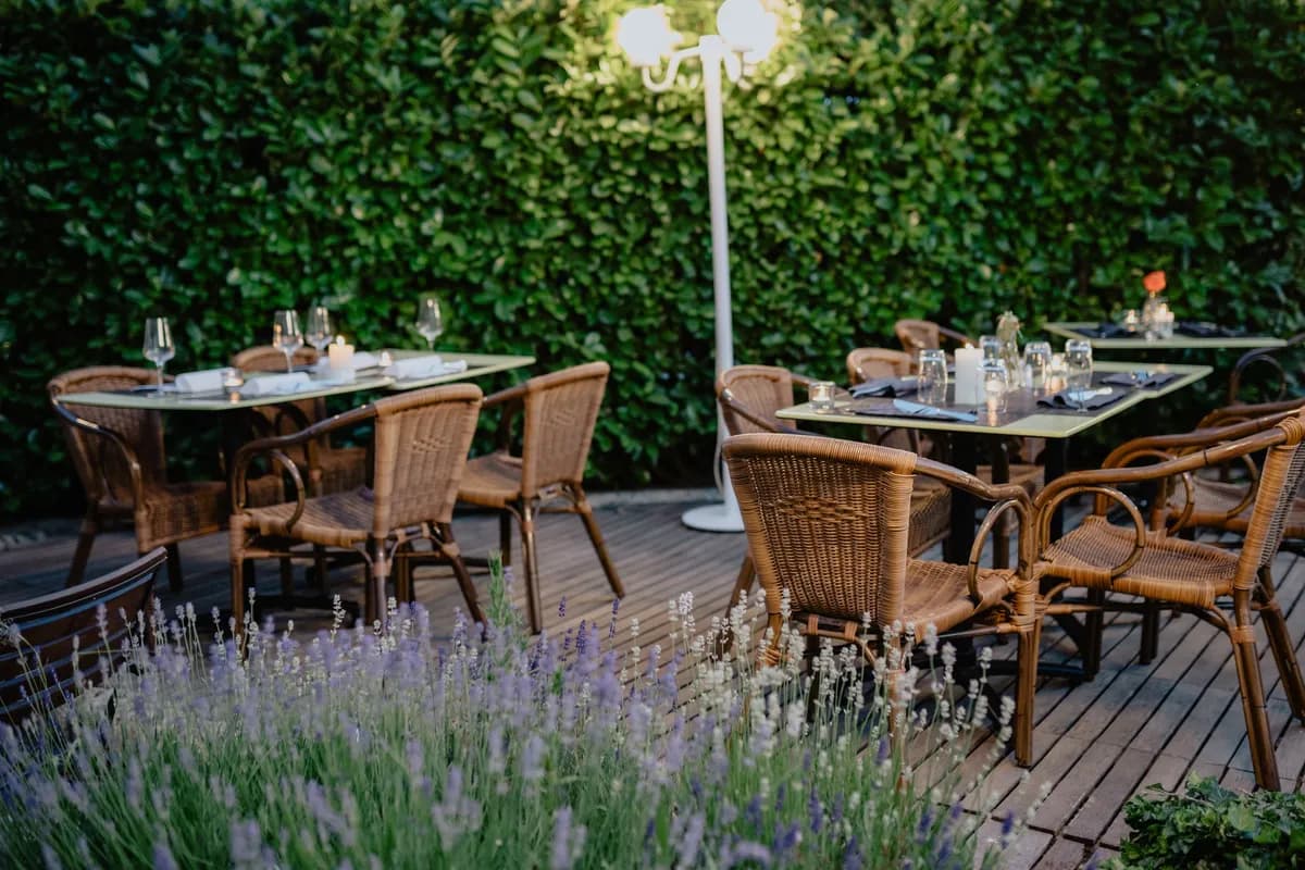 Immagine di esempio BookNoFees: tavoli apparecchiati e sedie di vimini su una terrazza accanto alla lavanda