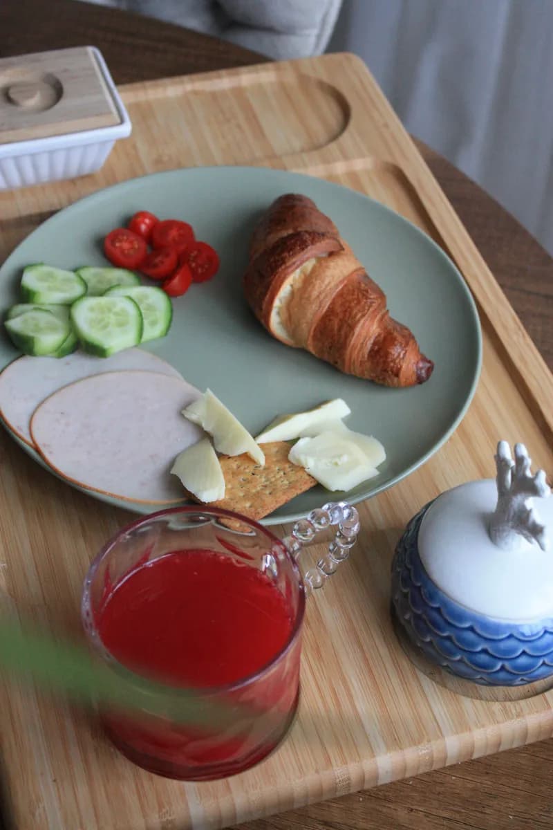 Immagine di esempio BookNoFees: vassoio della colazione con croissant, verdure e succo di frutta