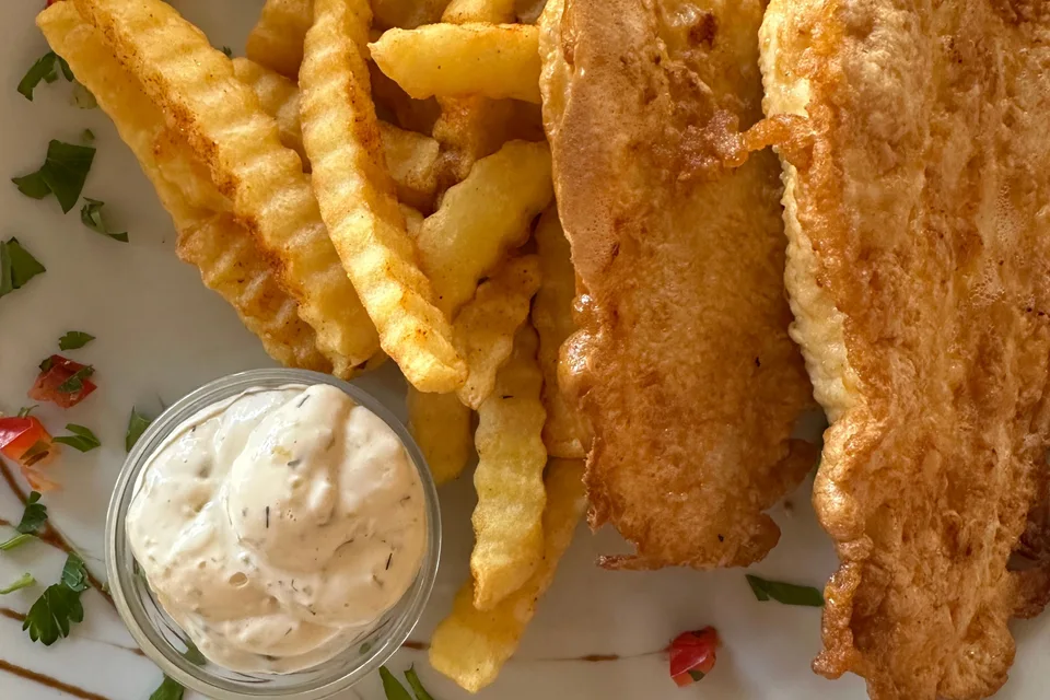 BookNoFees: Foto di esempio: Filetti di pesce impanati con patatine ondulate e una ciotolina di salsa