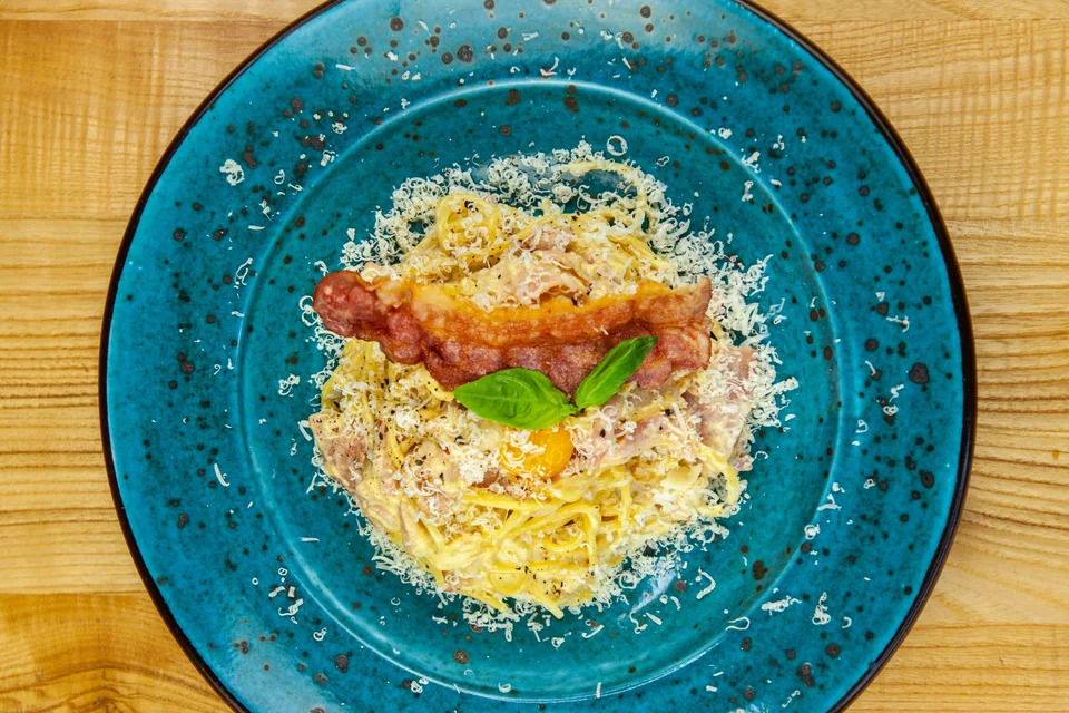 BookNoFees: Foto di esempio: Spaghetti alla carbonara su un piatto blu