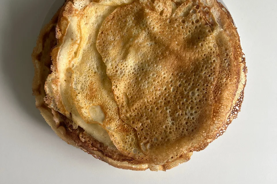 BookNoFees: Foto di esempio: Sottili frittelle dorate su un piatto bianco