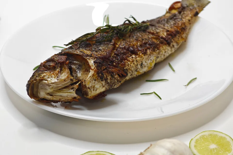 BookNoFees: Foto di esempio: Pesce intero alla griglia su un piatto bianco