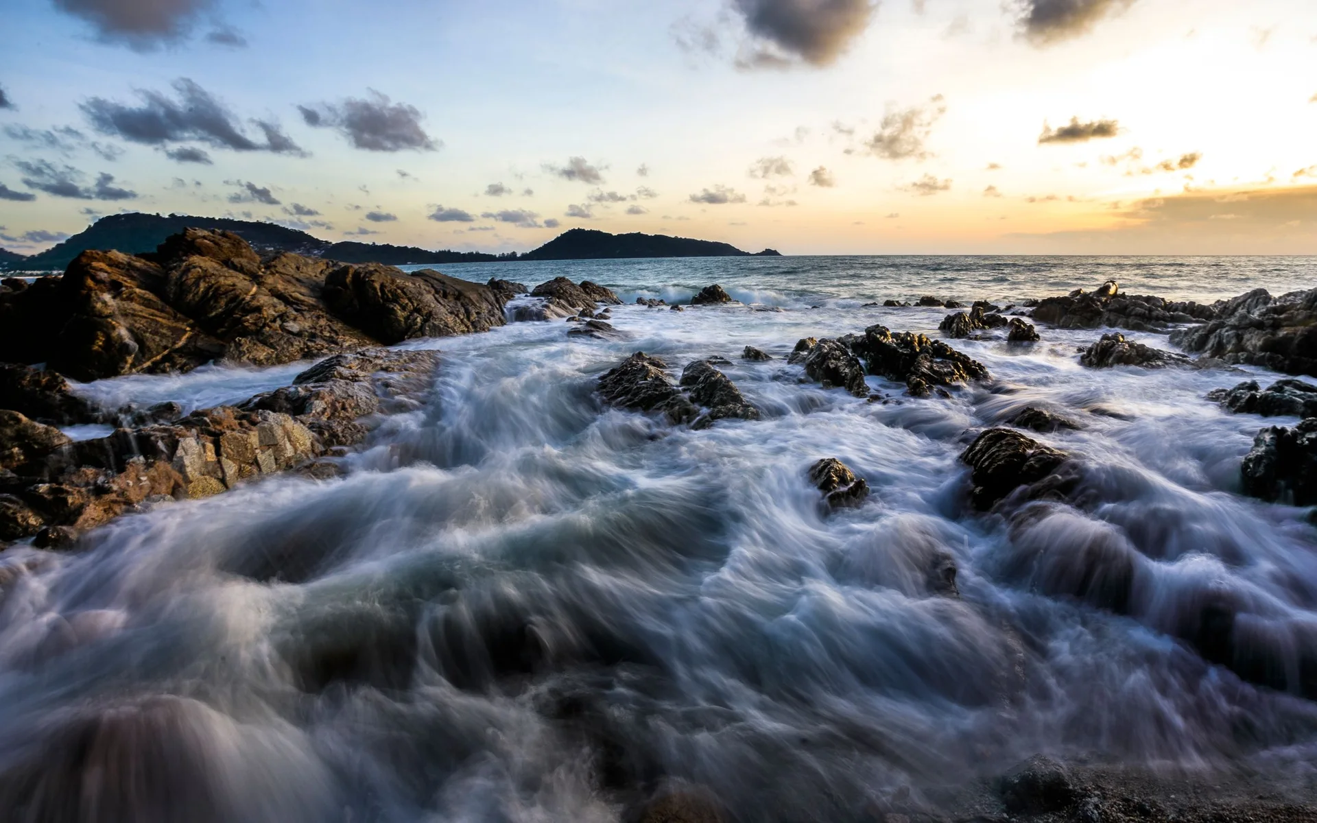 Onde sulla costa rocciosa di Phuket al tramonto