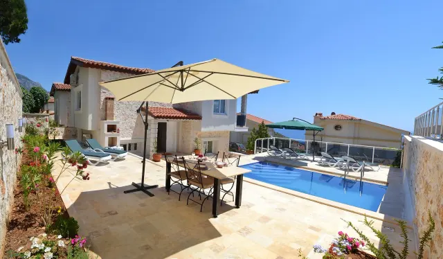 BookNoFees: casa vacanza a Kalkan, Kas, Antalya – Terrazza con tavolo da pranzo, ombrellone, piscina e lettini prendisole