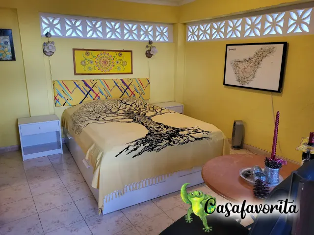 BookNoFees: casa vacanza a Buen Paso, Tenerife, Spagna – Camera da letto con letto matrimoniale, copriletto con motivi di alberi e finestre decorative in blocchi di cemento