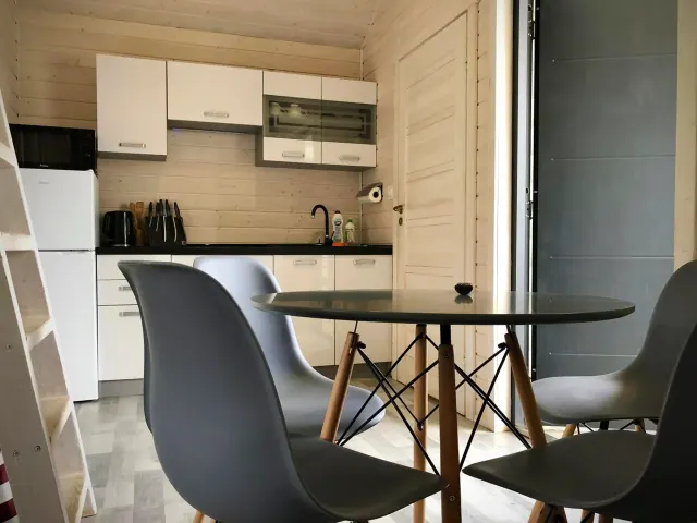 BookNoFees: casa vacanza a Jarosławiec, Polonia – una piccola cucina con tavolo e sedie nella struttura DOMKI SILVER 2 nella città di Jarosławiec