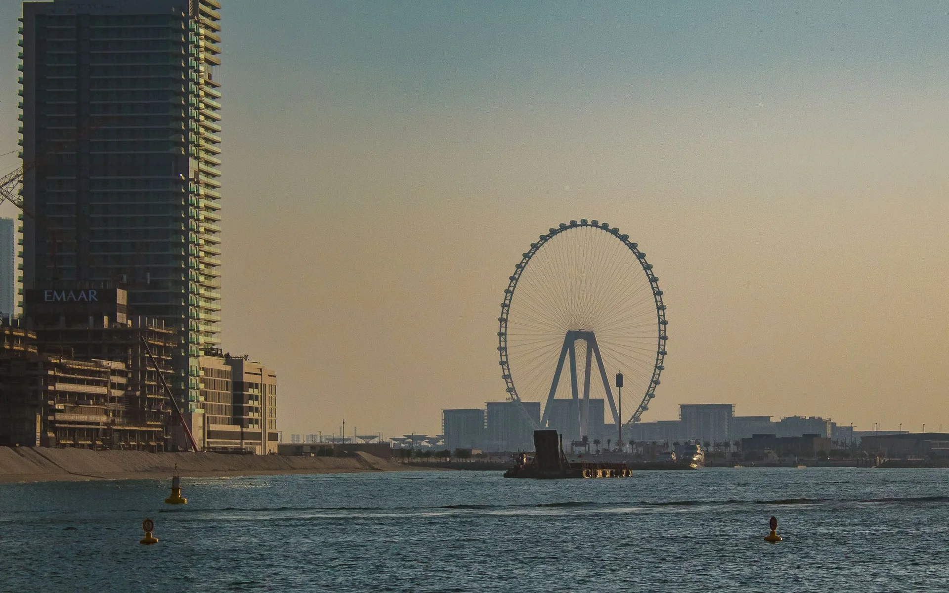 Skyline di Dubai con la ruota panoramica al tramonto