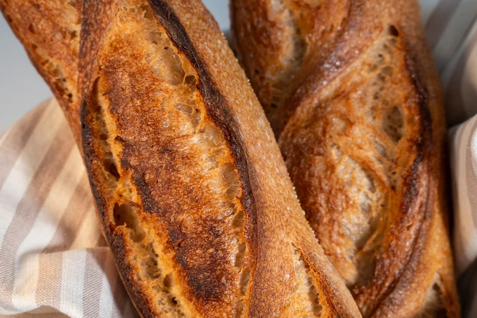 BookNoFees: Foto di esempio: Baguette dorate adagiate su una tovaglia a quadretti