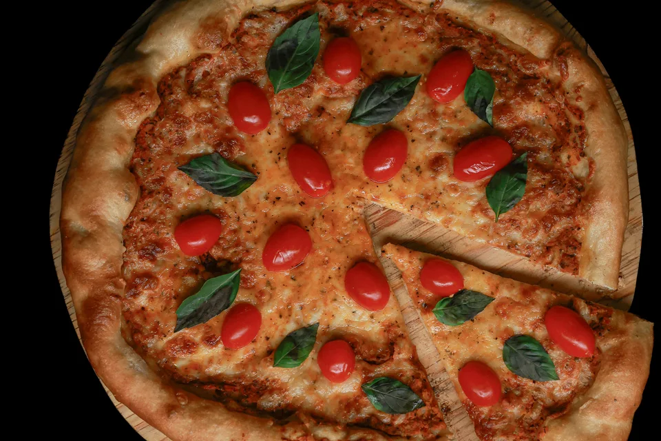 Foto di esempio: Pizza condita con pomodori e basilico